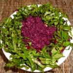 Grated beetroot in a tasty dressing, surrounded with finely sliced beetroot leaves